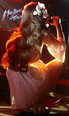 a woman sitting on the ground in front of a microphone