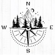 a compass with trees and mountains in the middle on a wooden background that says north