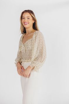 Nothing says summer like the Lemon Tart Smocked Top! This beautiful cropped blouse features a charming sweetheart neckline and knotted detail, plus its smocked bodice and bishop sleeves ensure maximum comfort while you're soaking up the sun. Pair with white denim for your favorite look of the season! FIT: Runs true to size. Cropped. MATERIAL: Self: 100% Polyester, Lining: 100% Polyester. GARMENT DETAILS: Lightweight floral print top, with sweetheart neckline and knotted detail bust. Features a smocked ribcage panel, with long bishop sleeves and elasticized shoulders. Lined. SIZE GUIDE: XS (0-2) / S (2-4) / M (6-8) / L (10-12) MODEL DETAILS: Mackenzie - Size S Heather - Size S Molly - Size XL Our Brunette Misses Model Our Blonde Misses Model Our Blonde Curve Model Bust 34" 34" 37" Waist 27. Flowy Smocked Top For Brunch, Spring Brunch Blouse With Smocked Bodice, Spring Flowy Smocked Top For Brunch, Spring Blouse With Smocked Bodice For Brunch, Chic Flowy Blouse With Smocked Bodice, Spring V-neck Peasant Top With Smocked Back, Spring Flowy Peasant Top With Smocked Back, Summer Flowy Blouse With Smocked Bodice, Chic Flowy Smocked Top With Smocked Cuffs