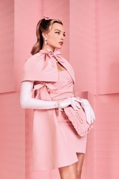 a woman in a pink dress and white gloves