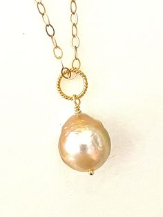 Gorgeous large 13mm golden peach freshwater cultured Kasumi like pearl wire wrapped on sparkling 14k gold fill cable chain.  Beautiful Chinese Kasumi Baroque pearl with characteristic iridescent bumpy surface is golden peach color and highly lustrous. Stunning single pearl displays a gorgeous array of metallic colors in the light. You will receive this exact Pearl.  Pearl is wire wrapped in 14k gold fill and  hangs from sparkling flat cable chain. Total pendant length with twisted 24k gold verme Handmade Gold Pearl Necklace With Briolette, Gold Pear-shaped Single Strand Pearl Necklace, Gold Oval Pearl Necklace With Pearl Charm, Oval Gold Pearl Necklace With Pearl Charm, Gold Briolette Pearl Necklace, Gold Baroque Pearl Jewelry, Wire Wrapped, Gold Oval Baroque Pearl Jewelry, Oval Baroque Pearl Jewelry In Gold, Exquisite Gold Baroque Pearl Jewelry