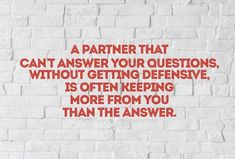 a brick wall with a quote on it that says, a partner that can't answer your questions without getting defensive is often keeping more from you than the answer