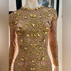 a mannequin wearing a gold and pink dress