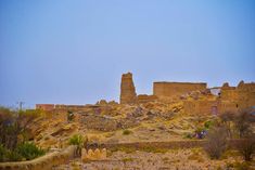 an old castle sits on top of a rocky hill