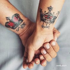 two people are holding hands with tattoos on their arms and the other hand has a crown tattooed on it