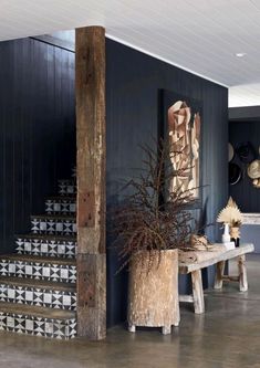 a wooden table sitting next to a set of stairs in a room with blue walls