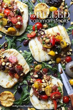 grilled calamari steaks with tomatoes, olives and corn on a baking sheet