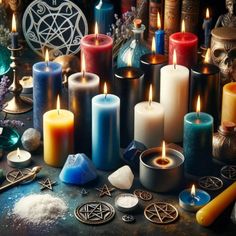 many different colored candles are sitting on a table with other items around them and there is a pen in the middle