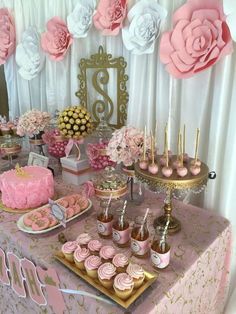 a table topped with pink and gold desserts