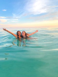 two women are floating in the ocean together