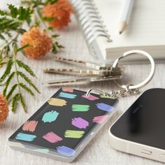 a phone case sitting on top of a desk next to a cellphone and flowers