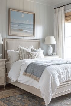 a white bed sitting in a bedroom next to two lamps on either side of the bed