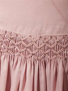 a close up of a pink dress with crochet on the waist and bottom