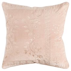 a beige pillow with an embroidered design on the front and back, sitting against a white background