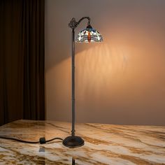 a lamp that is sitting on top of a marble table next to a curtained window