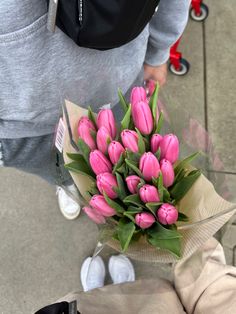 a bouquet of pink tulips is wrapped in clear cellophane and placed on the ground