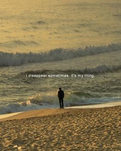 a man standing on top of a sandy beach next to the ocean