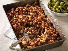 a pan filled with stuffing next to a bowl of brussels sprouts