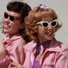 two women in pink jackets and sunglasses posing for the camera