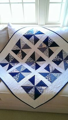 a blue and white quilt sitting on top of a couch