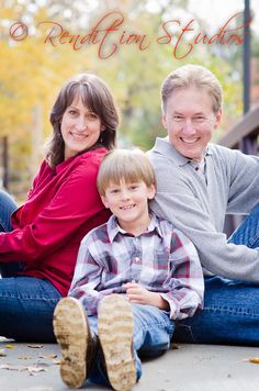 a family sitting on the ground with their arms around each other