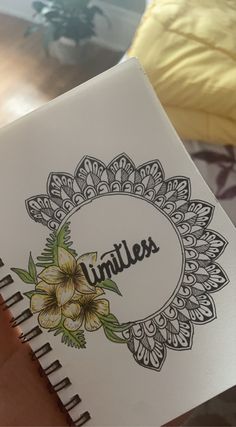 a hand holding a notebook with the word limitless written in black ink on it