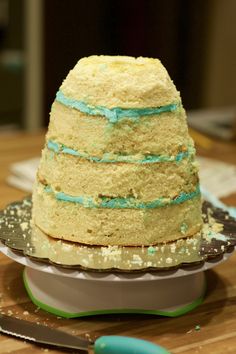 a layered cake sitting on top of a plate next to a knife and spatula