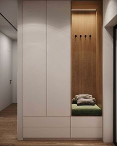 an empty room with white cabinets and green cushion on the bench in front of it