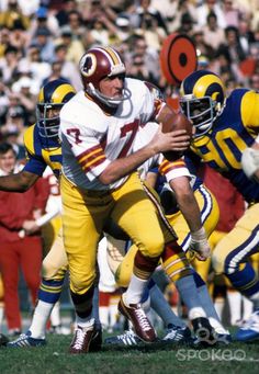 a football player is getting ready to throw the ball during a game with other players in the background