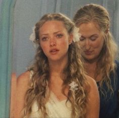 two girls with long hair and flower in their hair