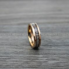 two wedding bands with gold and silver inlays on a wooden surface, one is made out of antelope wood