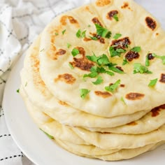 a stack of pita bread sitting on top of a white plate