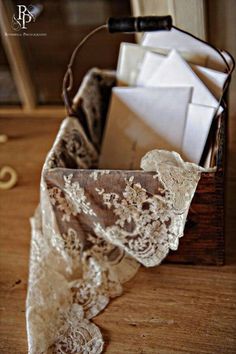 an open box with lace on it sitting on top of a wooden table