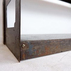 an old metal shelf with a mirror on the top and one side missing from it