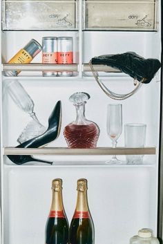 an open refrigerator filled with bottles and glasses