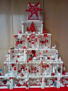 a white christmas tree with red ornaments on it