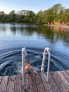 a woman is sitting in the water on a dock with her head above the water