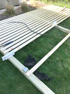 two black shoes are laying on the ground next to a wooden bench that is being built