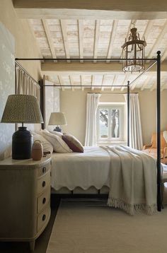 a bedroom with a four poster bed and white walls