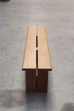 a wooden bench sitting on top of a cement floor