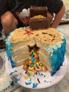 a cake that has been cut into pieces and is being held by a boy in front of it