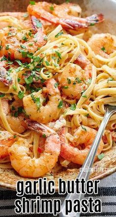 a bowl filled with pasta and shrimp on top of a table