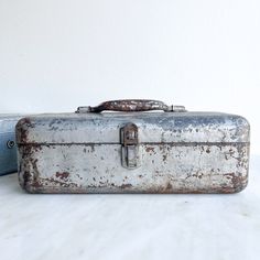 an old suitcase sitting on top of a white table