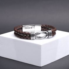 Discover the "Infinity Knot Bracelet" for men, crafted from leather and stainless steel for durability and style. Personalize it with an engraving inside the clasp for a meaningful gift for your husband or any special man. Ideal for anniversaries or birthdays, the infinity symbol signifies eternal love, making this bracelet a unique and cherished present. Genuine Leather Stainless steel charm and clasp Width : 14mm/0.55" Elegant Brown Leather Bracelet With Stainless Steel Clasp, Adjustable Leather Bracelet With Stainless Steel, Classic Leather Bracelet With Stainless Steel Clasp Gift, Silver Leather Bracelet With Stainless Steel Clasp, Stainless Steel Braided Bracelets With Clasp As Gift, Elegant Adjustable Leather Bracelet For Father's Day, Stainless Steel Braided Bracelet As Gift, Elegant Stainless Steel Leather Bracelet, Brown Leather Bracelet With Engraving Option