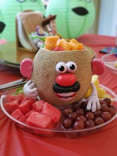 there is a fruit bowl with a clown face on it and some watermelon