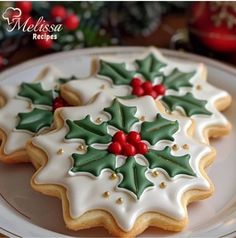 christmas cookies decorated with holly and red berries on a white plate, ready to be eaten