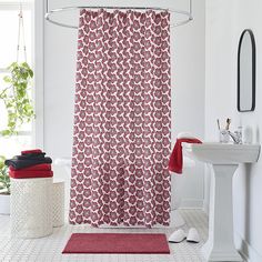 a bathroom with a red shower curtain next to a white sink