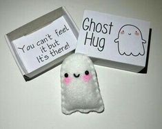 two small white ghost magnets in a box on a table next to a sign that says you can't feel it but it's there