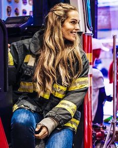 a woman sitting in the back of a fire truck