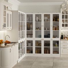 a white kitchen with lots of glass cabinets